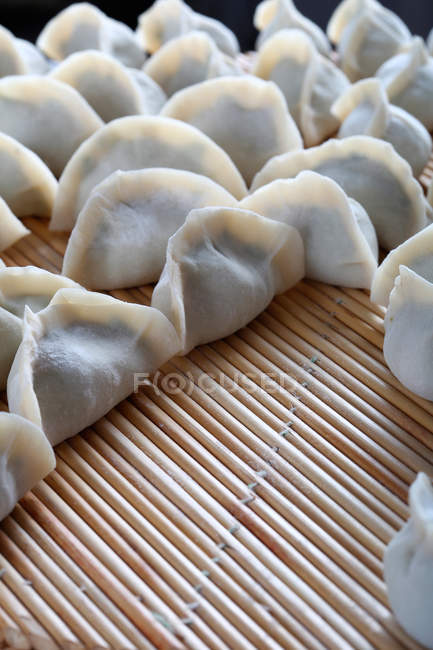 Close-up view of delicious traditional chinese dumplings on bamboo surface — Stock Photo