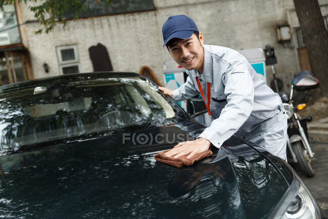 Молодой человек уборка автомобиля — стоковое фото