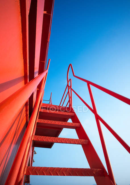 Vista a basso angolo della gru a portale industriale rossa contro il cielo blu — Foto stock