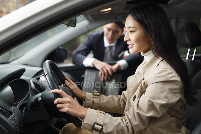 Mujer sentada en un coche con prueba de manejo - foto de stock