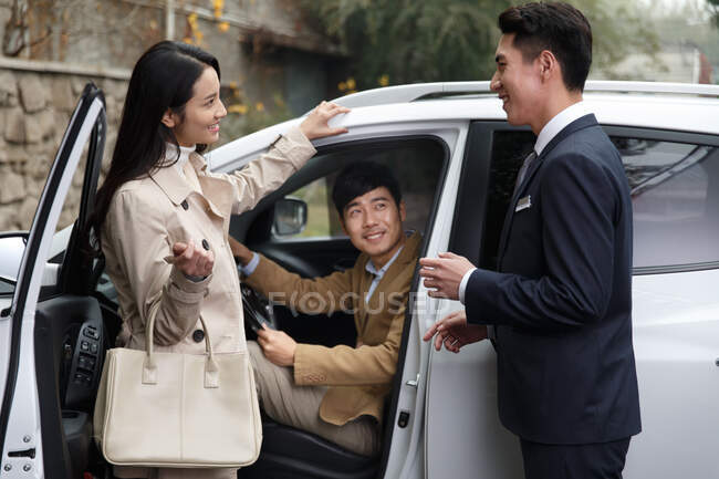 Vendedor de coches hablando con la pareja - foto de stock