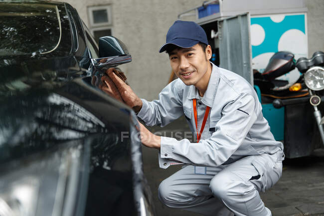 Giovane uomo pulizia auto — Foto stock
