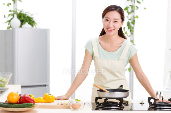 Young woman cooking in kitchen — Stock Photo