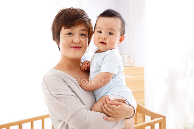 Madre sosteniendo al bebé - foto de stock