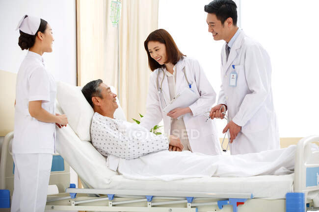 Медицинские работники и пациенты в отделении — стоковое фото