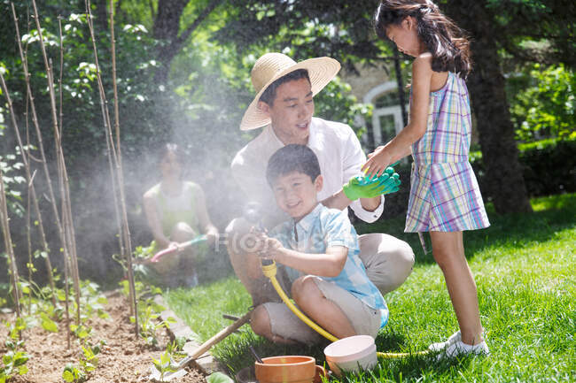 Happy family in the garden vegetables — Stock Photo
