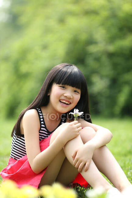 Портрет дівчини, що сидить на траві — стокове фото