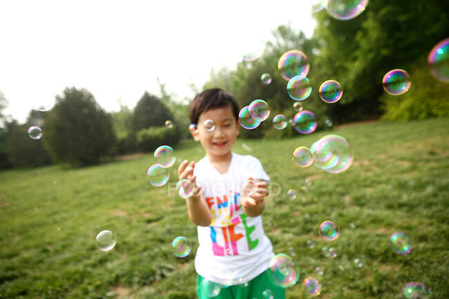 Мальчик делает мыльные пузыри на открытом воздухе — стоковое фото