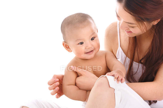 Feliz jovem mãe segurando adorável bebê em casa — Fotografia de Stock