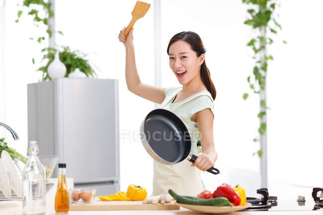 Jeune femme cuisine dans la cuisine — Photo de stock