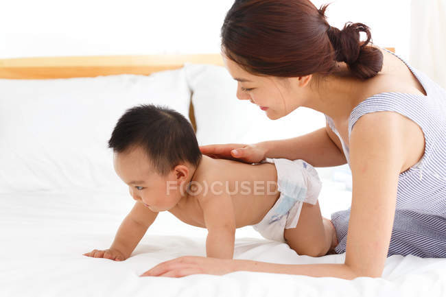 Happy young mother looking at cute baby at home — Stock Photo