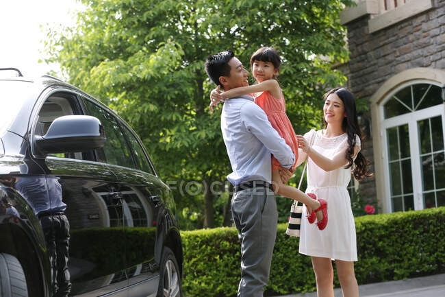 Famiglia felice in piedi accanto alla macchina — Foto stock