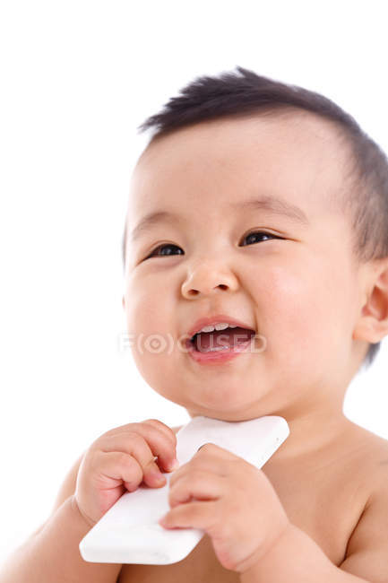 Lindo asiático bebé chico holding smartphone y mirando lejos - foto de stock