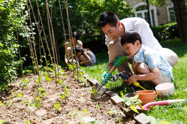 Família feliz nos legumes do jardim — Fotografia de Stock