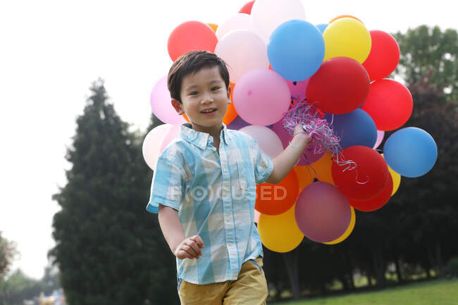Junge hält Ballons in der Hand — Stockfoto