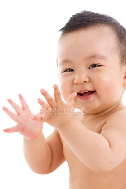 Милый веселый ребенок хлопает в ладоши и смотрит в камеру на белом фоне — стоковое фото