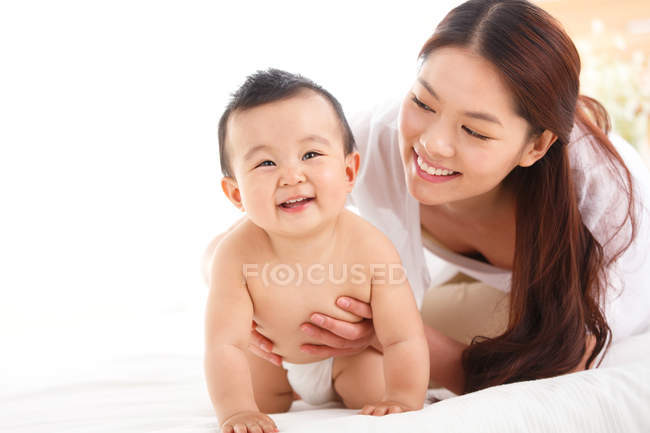 Happy young mother with cute baby at home — Stock Photo