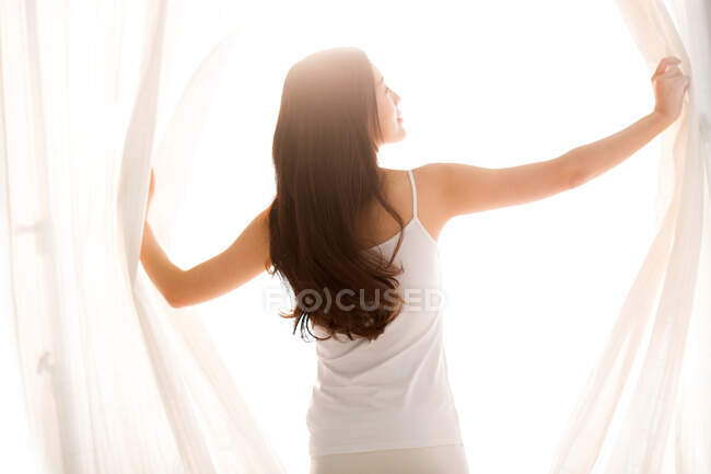 Beautiful young woman in bedroom — Stock Photo