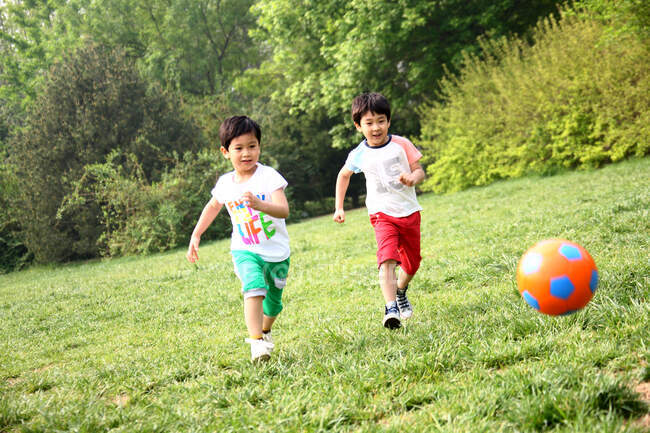 Chicos jugando al fútbol en el campo - foto de stock
