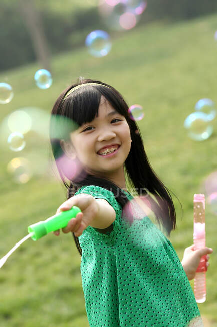 Girl making soap bubbles outdoors — Stock Photo
