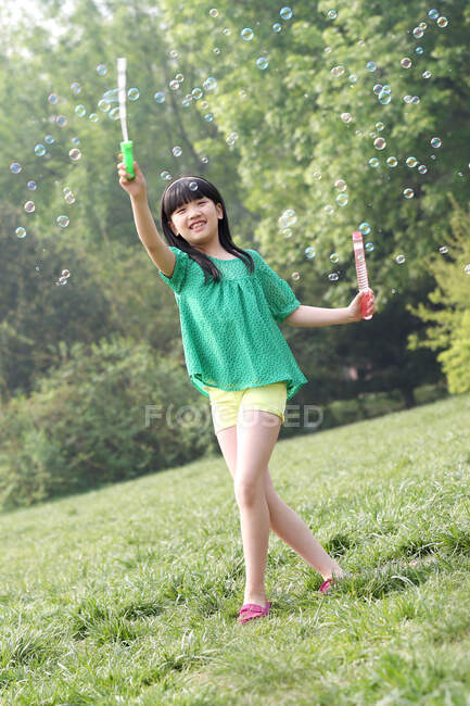 Девушка делает мыльные пузыри на открытом воздухе — стоковое фото