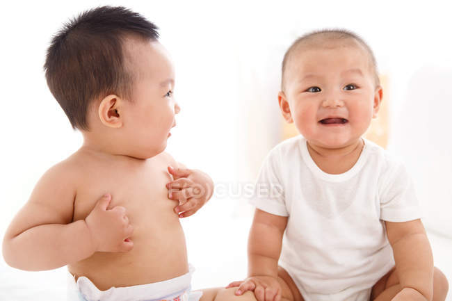 Two adorable happy asian babies sitting together — Stock Photo