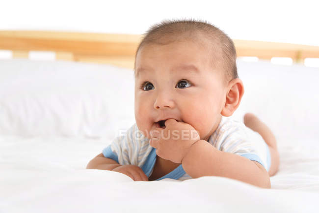 Primo piano vista di adorabile asiatico bambino sdraiato su letto — Foto stock
