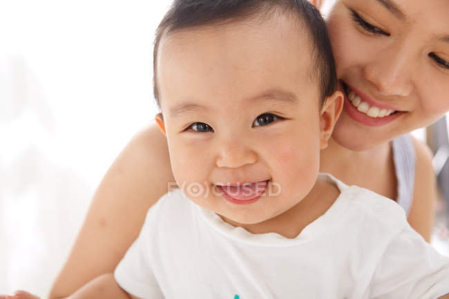 Felice giovane madre con bambino carino a casa, colpo ritagliato — Foto stock