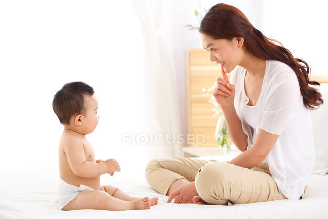 Glücklich junge asiatische Mutter spielt mit entzückenden kleinen Baby zu Hause — Stockfoto