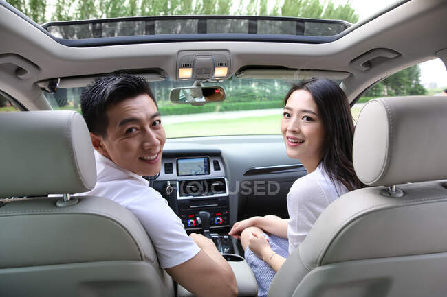 Les jeunes couples conduisent une voiture — Photo de stock