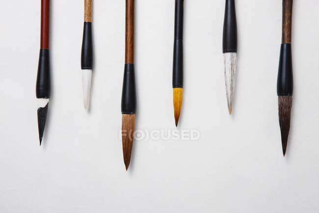 Still life of calligraphy brushes on grey background, close-up view — Stock Photo