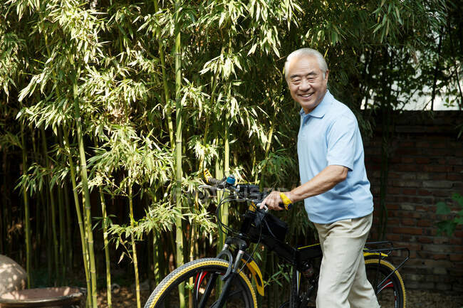 Старший чоловік з велосипедом — стокове фото