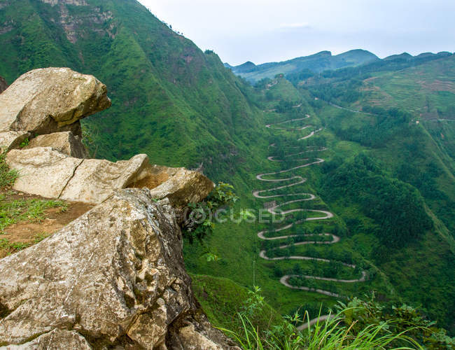 Paysage étonnant avec route sinueuse et montagnes couvertes de végétation verte, province du Guizhou, comté de Qinglong, Chine — Photo de stock