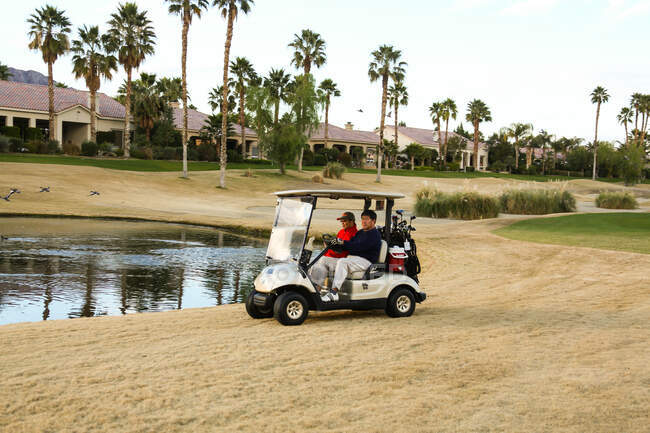 Двое мужчин за рулем гольф-кара — стоковое фото