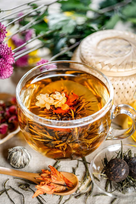 Крупный план здорового органического травяного чая в чашке на столе — стоковое фото