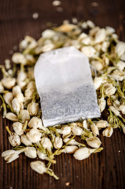 Tea bag with dried flowers on wooden table, close-up view — Stock Photo