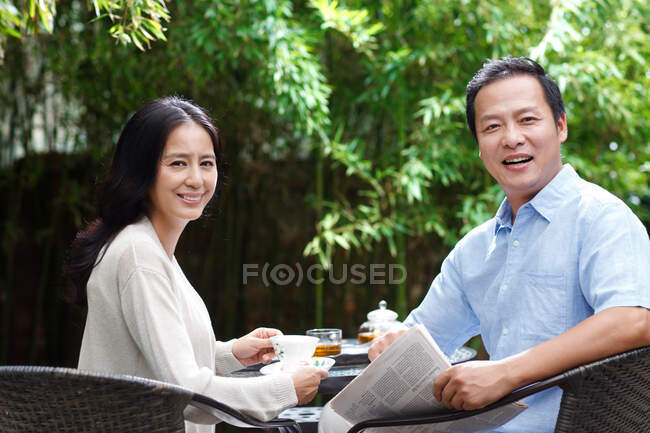 El ocio de las parejas de mediana edad en el patio - foto de stock