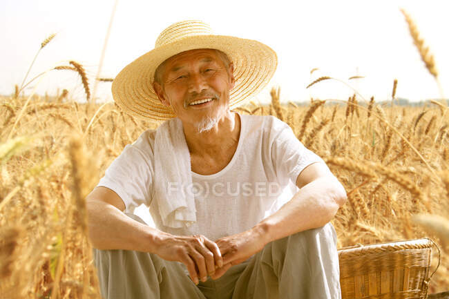 Agricultor maduro sentado no campo — Fotografia de Stock