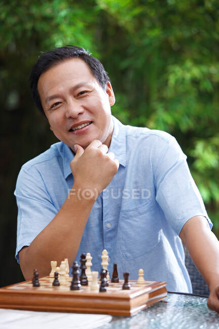 El hombre de mediana edad en el ajedrez - foto de stock
