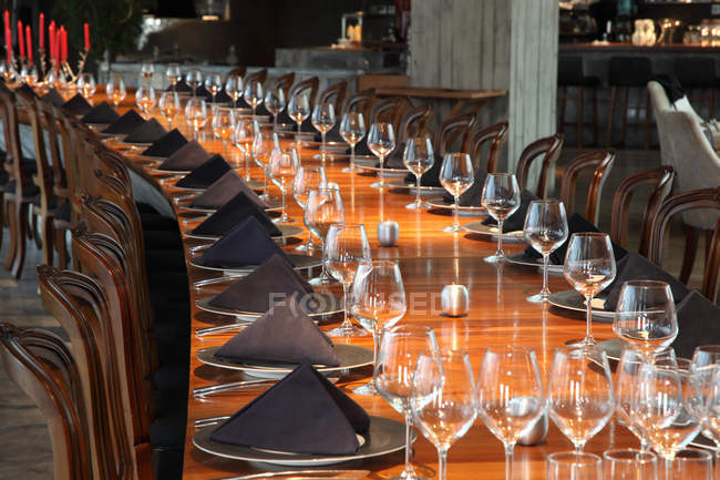 Elegante tavolo servito con bicchieri vuoti, piatti e tovaglioli al ristorante — Foto stock