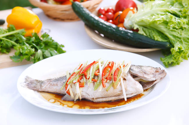 Крупный план вкусной еды с рыбой и овощами на тарелках — стоковое фото