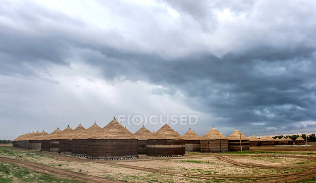 Jilin Chagan Lake cenário com cabanas de grama em dia nublado — Fotografia de Stock