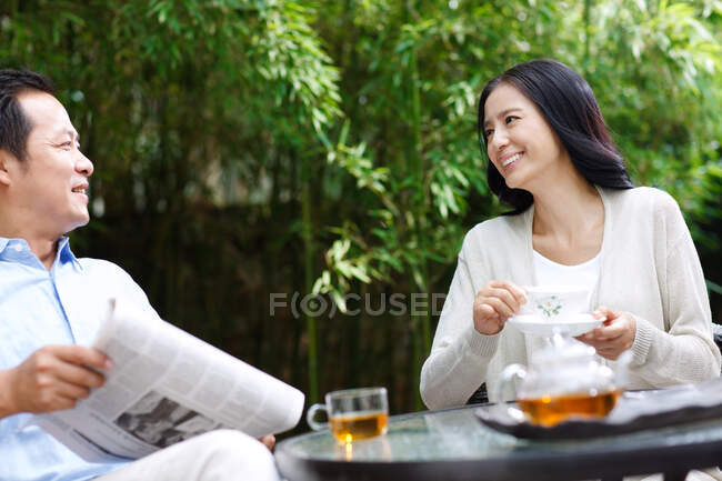 El ocio de las parejas de mediana edad en el patio - foto de stock