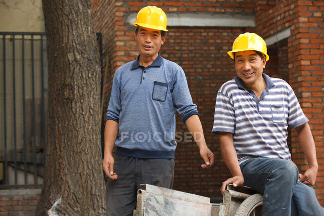 Retrato de dos trabajadores de la construcción - foto de stock