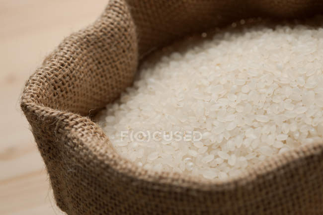 Vista close-up de arroz branco saudável no saco de serapilheira, foco seletivo — Fotografia de Stock