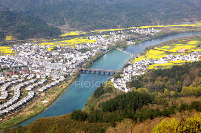 Повітряний вид на пейзаж Аньхой Кіюньшань з будинками, річкою та мостом. — стокове фото