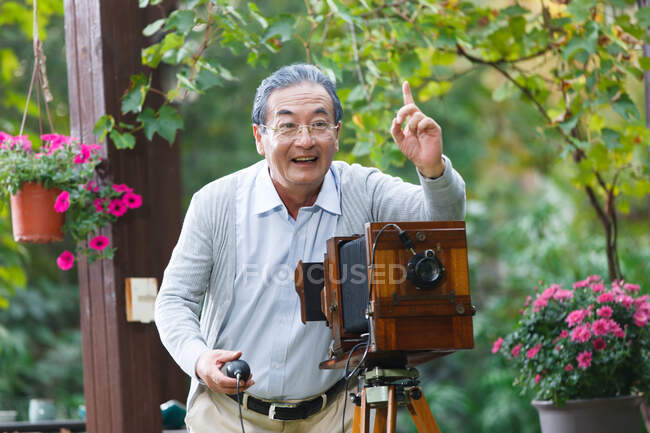 The old man is using old-fashioned camera — Stock Photo