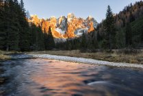 Puesta de sol de otoño ilumina los picos altos, Valle de Venagia, Parque Natural de Panaveggio, Dolomitas, Trentino-Alto Adigio, Italia - foto de stock