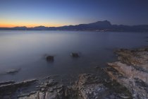 Twilight on Garda lake with Pizzoccolo peak in background, Sirens bay, Garda lake, Veneto, Italy — Stock Photo