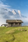 Cabañas de montaña frente a las montañas del grupo Sella, Passo Gardena, Dolomitas, Tirol del Sur, Italia - foto de stock